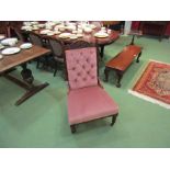 An Edwardian walnut button back open armchair with carved decoration over turned legs and ceramic