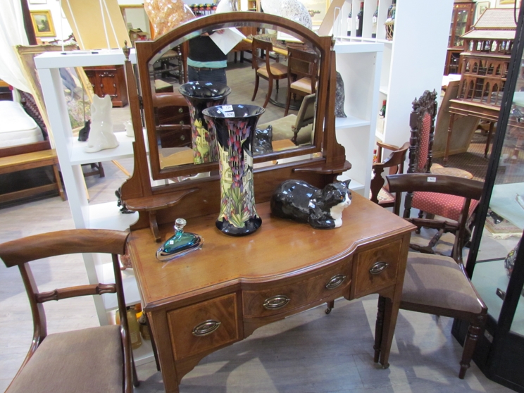 An Edwardian crossbanded mahogany breakfront dressing table the brass finials and tilting bevelled