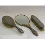 A silver three piece dressing table set