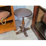 An 18th Century oak wine table the chamfered edge circular top on a turned baluster column and