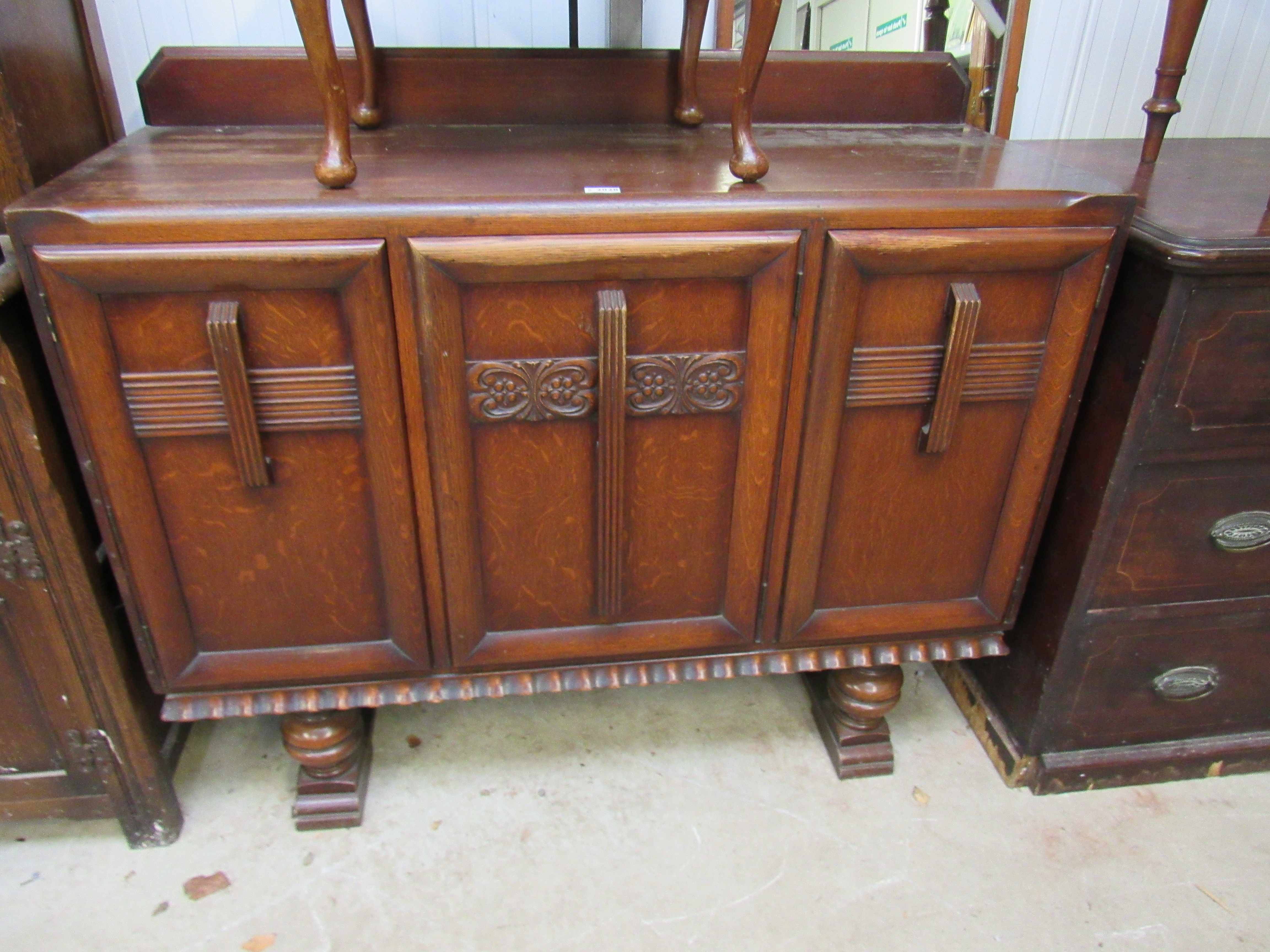 A 1940s oak three door sideboard with drawers to interior