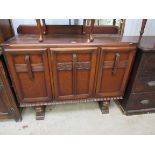 A 1940s oak three door sideboard with drawers to interior