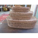 A set of three graduating wicker lidded baskets