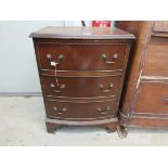 A reproduction mahogany bow fronted three drawer bedside chest