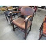 An Arts & Crafts oak desk chair with brass studded leather upholstery