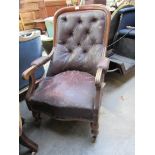 An early 19th Century mahogany and leatherette button-back scroll arm armchair