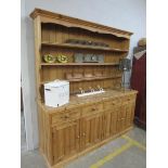 A large pine kitchen dresser with open plate rack over four drawers and four doors 220 w x 214cm