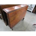 An early Victorian walnut Sutherland table on white ceramic castors