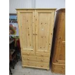 A pine two door wardrobe over two over two drawer base
