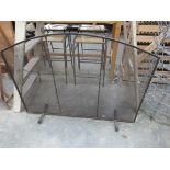 A wrought iron and mesh fire guard,