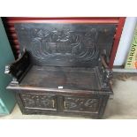 An Edwardian carved oak monks bench, with lift up seat,