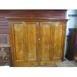 A Georgian mahogany four door wardrobe with hanging, shelved and drawer interior,