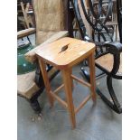 A pine stool with grab hole seat