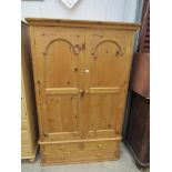 A pine two door wardrobe on three drawer base,
