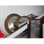 Three circular gilt framed mirrors,