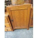 A 1930s light oak single door cupboard