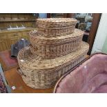 A set of three graduating wicker lidded baskets