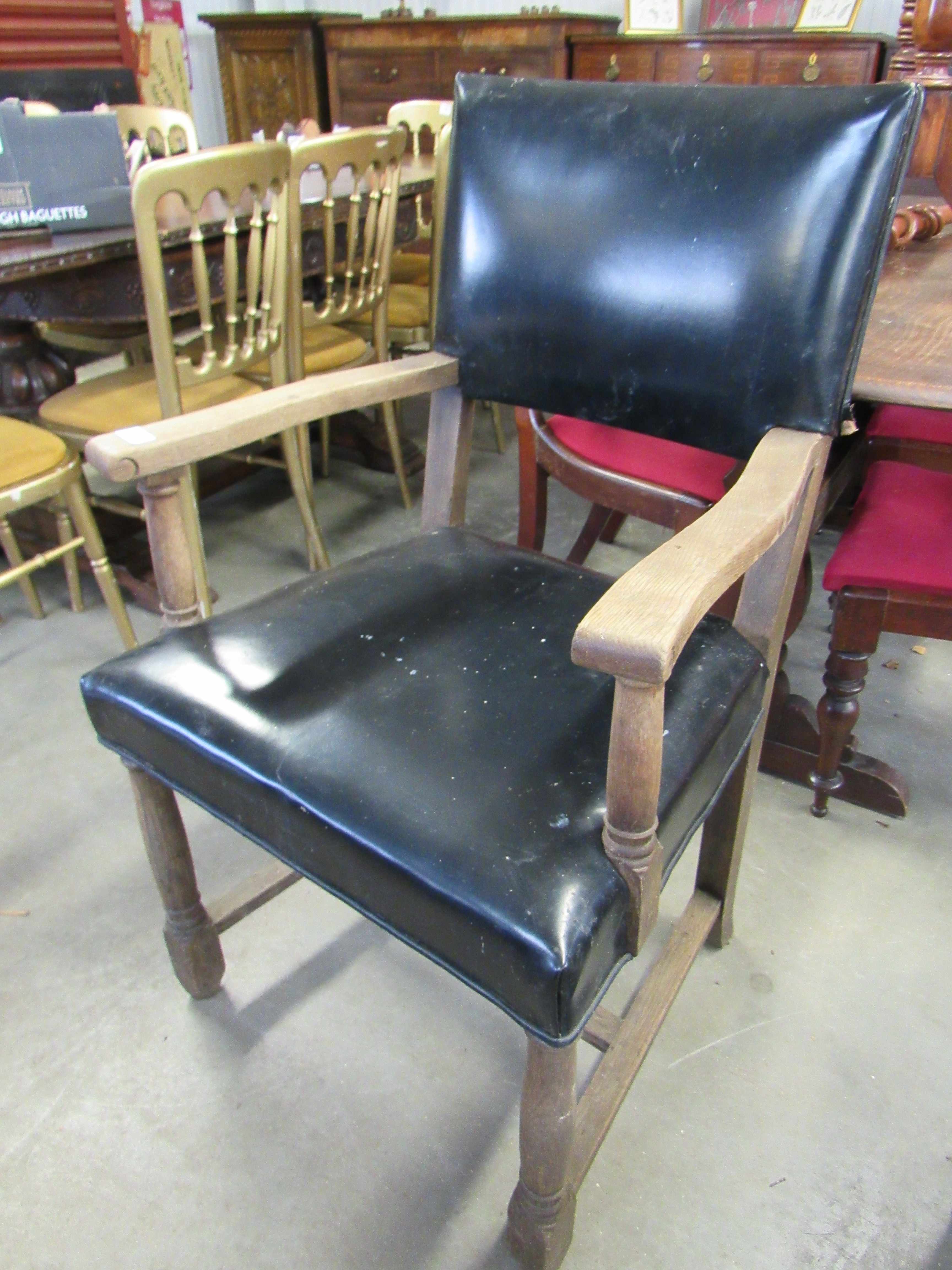 A 1930s oak framed elbow chair with leather seat and back