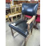 A 1930s oak framed elbow chair with leather seat and back