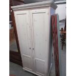 A modern white washed pine two door wardrobe