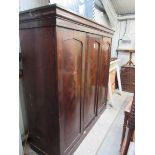 A Victorian mahogany three door wardrobe with tray and hanging space interior