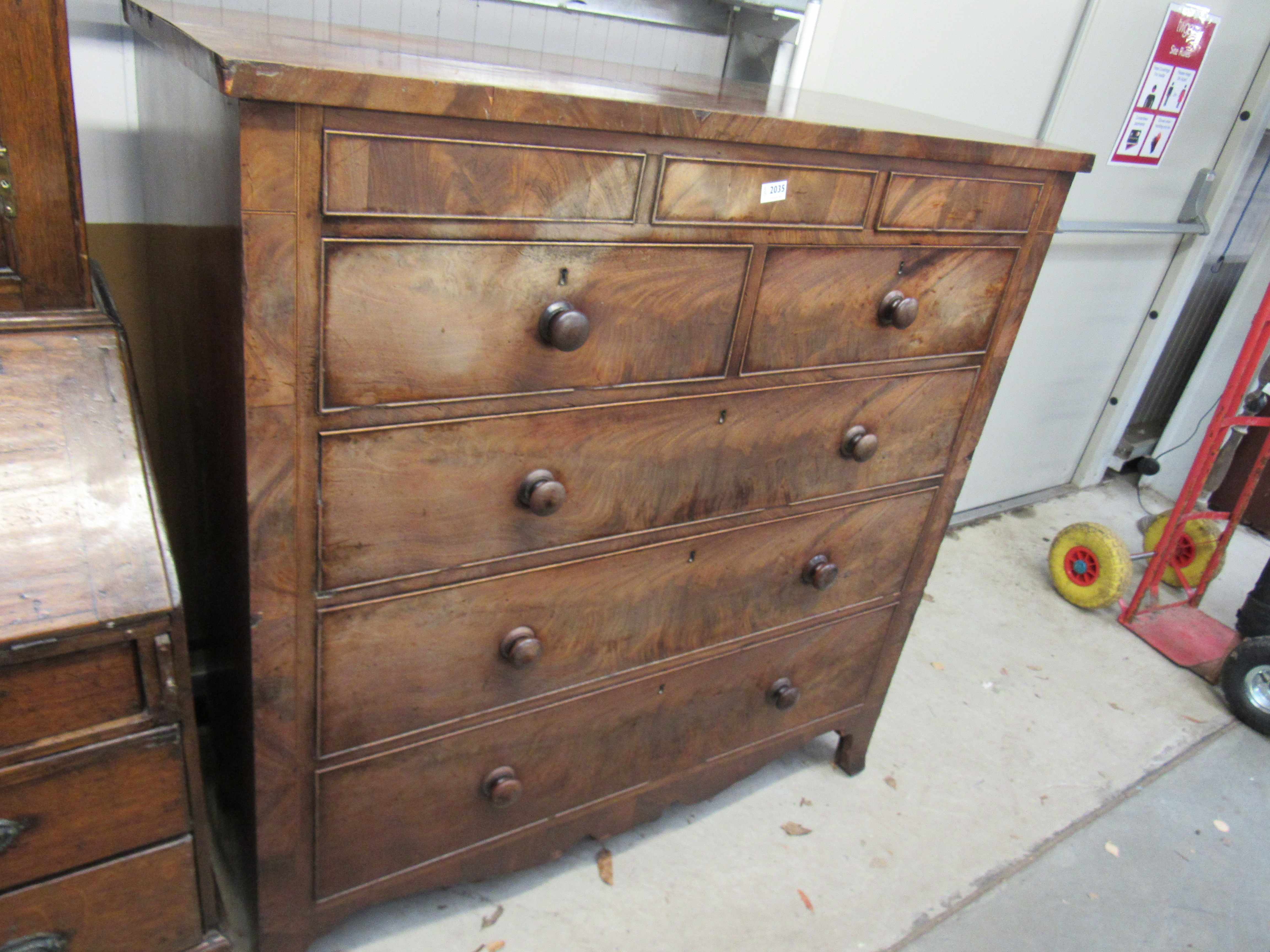 A George III flame mahogany chest of two secret drawers over two short and three long on outswept