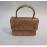 A 1960's leather pale pink crocodile skin handbag with hoop handle and flap front clasp.