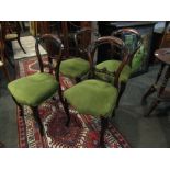 A set of four Victorian walnut balloon back dining chairs, sprung stuffed serpentine front seats,