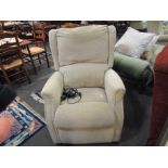 A beige chenille upholstered reclining electric armchair
