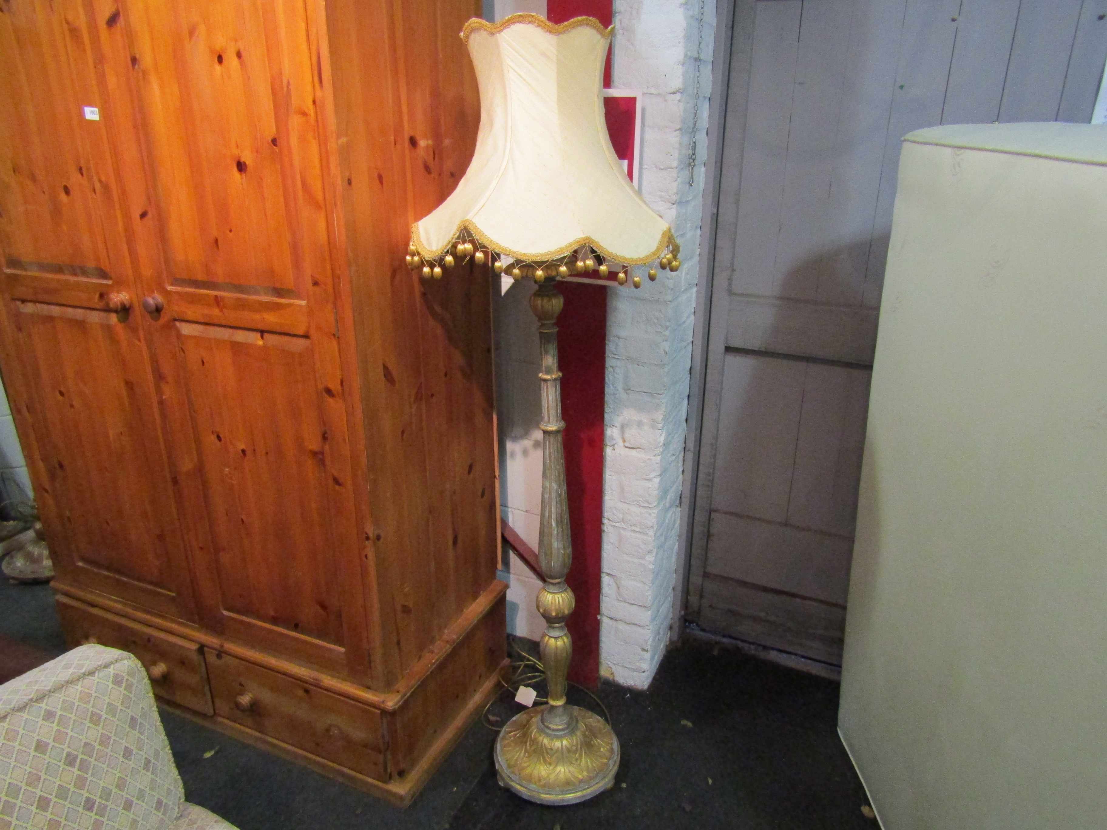 A classical gilded wood standard lamp with tasselled shade