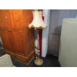A classical gilded wood standard lamp with tasselled shade