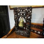 An early 20th Century Chinese hardwood carved and inlaid temple bell stand with brass bell,