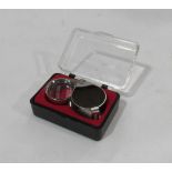 A cased 30x metallic jeweller's loupe