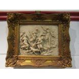 A marble effect high relief gilt framed plaque,