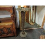 An embossed brass trumpet floor vase of tall proportions,