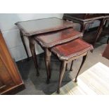 A nest of three reproduction mahogany coffee tables with glass tops