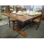 An 18th Century style oak refectory dining table on turned legs and sledge feet joined by a