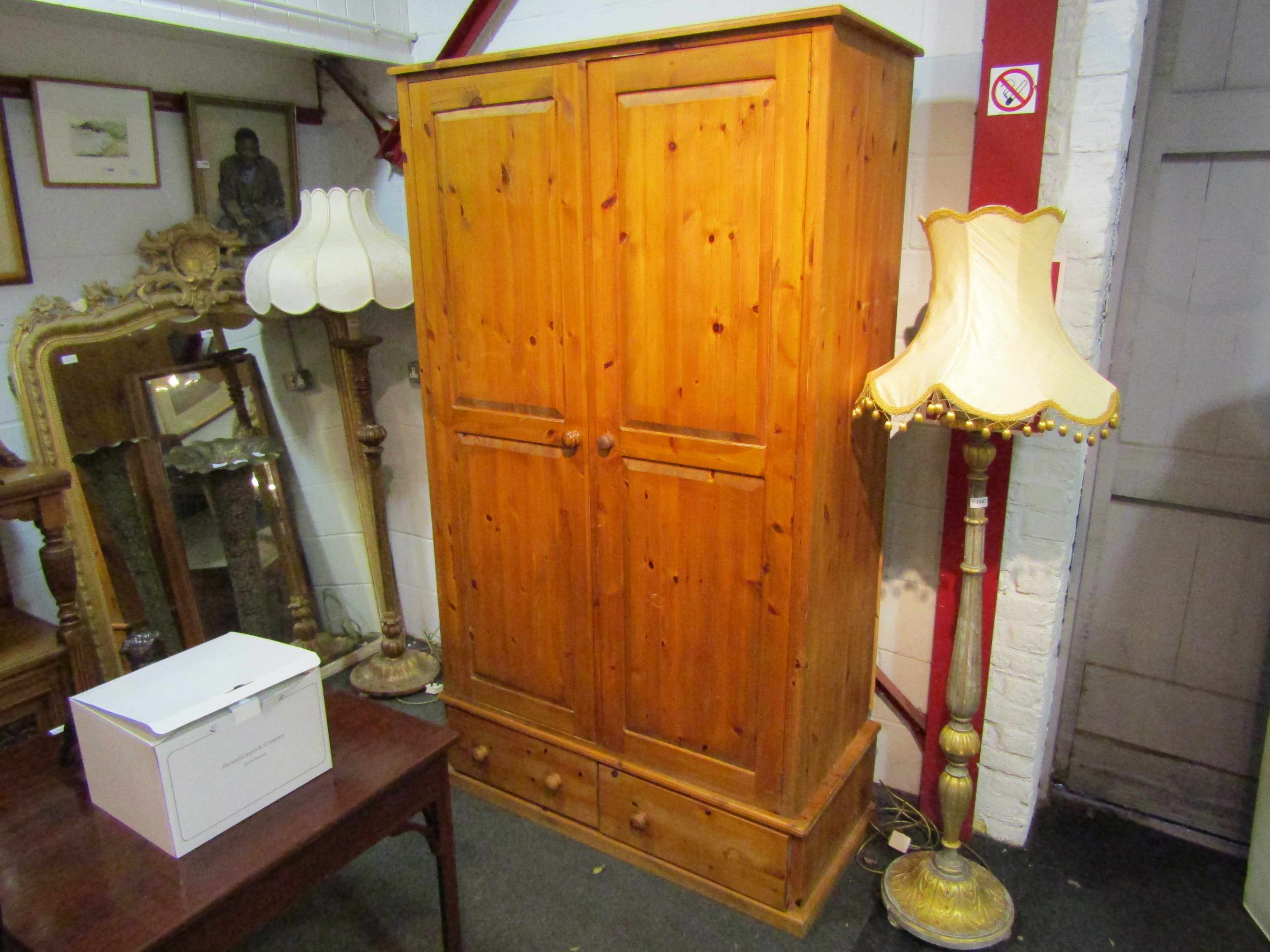 A modern pine two door wardrobe on two drawer base