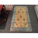 A green and beige ground wool rug with flora and fauna field and border, 3' x 6' approx.