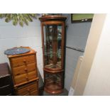 A cherry wood corner cabinet