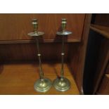 A pair of ecclesiastical style slender brass candlesticks