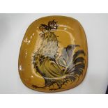 A British studio pottery slipware dish by David Eeles of cockerel design