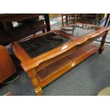 A cherrywood coffee table with glass top over undertier