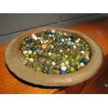 A copper tray of mixed marbles