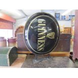 A wall mounted Guinness domed double sided sign