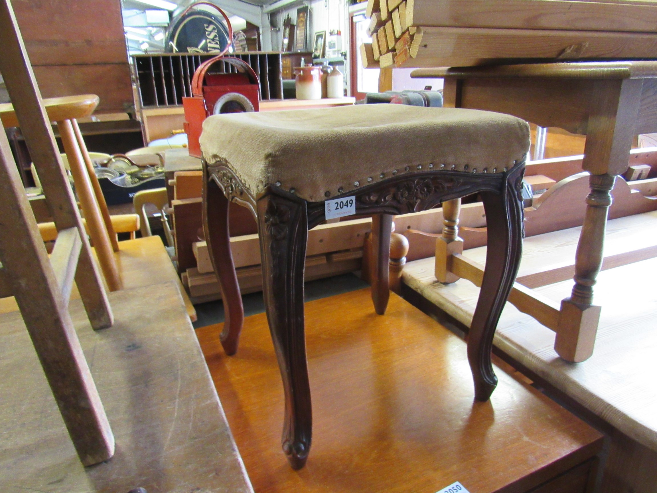 A carved upholstered stool