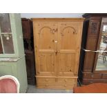 A pine two door wardrobe on three drawer base,