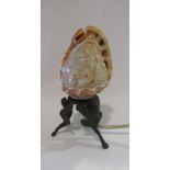 A carved cameo shell lamp with cast metal base,