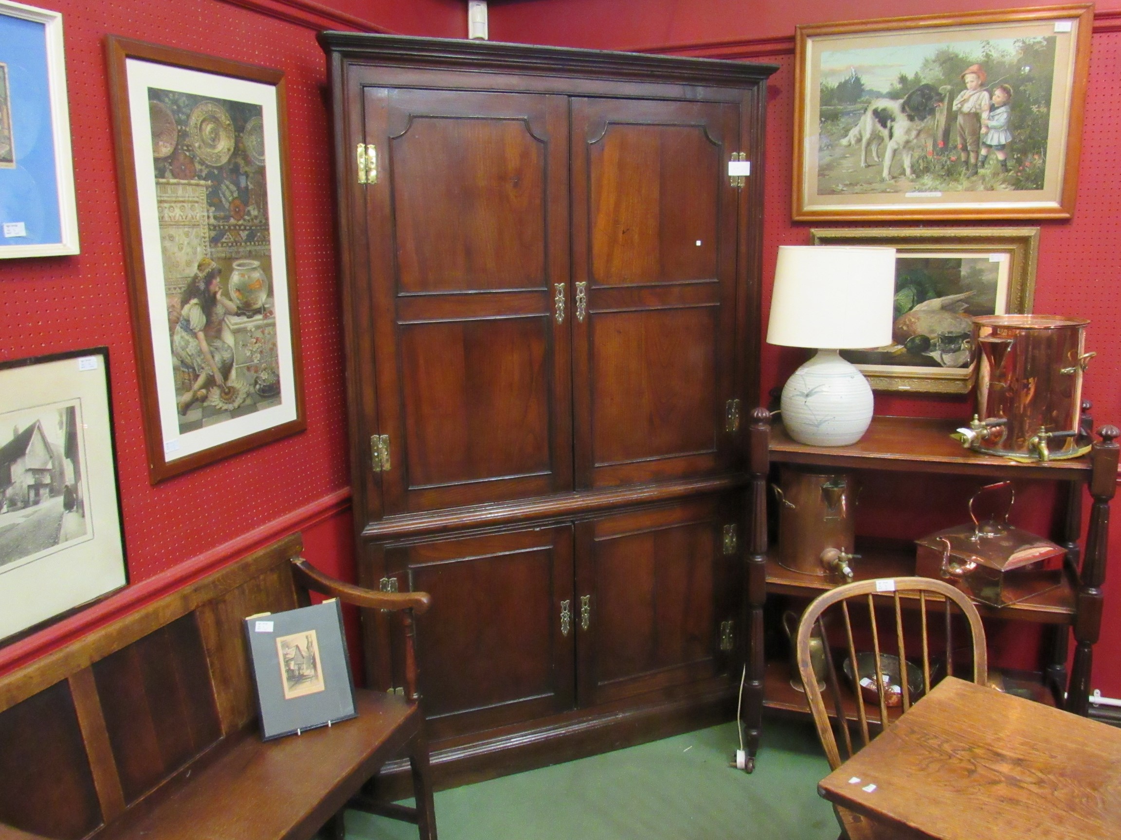 A Georgian oak four door corner cupboard with shaped shelf interior to top,