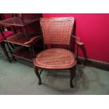 Circa 1920 an elm and ash caned elbow chair the outswept scroll arms on turned supports and